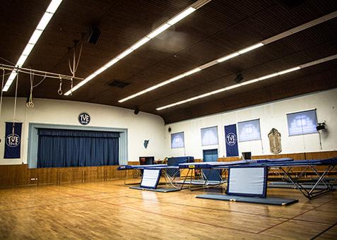Innenansicht Jahnhalle Erlangen Innenansicht der Jahnhalle mit mehreren aufgebauten Trampolinen und Turnringen.
