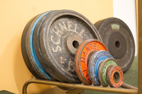 Gewichtsscheiben im Kraftraum Mehrere Gewichtsscheiben in verschiedenen Größen auf einem Ablageständer.