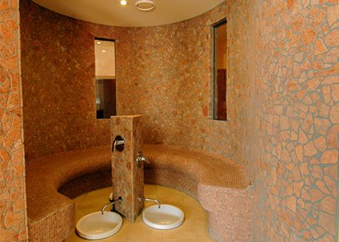 Wellnessbereich im TV Vital Runder Sitzbereich aus Naturstein mit integrierten Fußbecken in der Wellnesslandschaft des TV Vital.